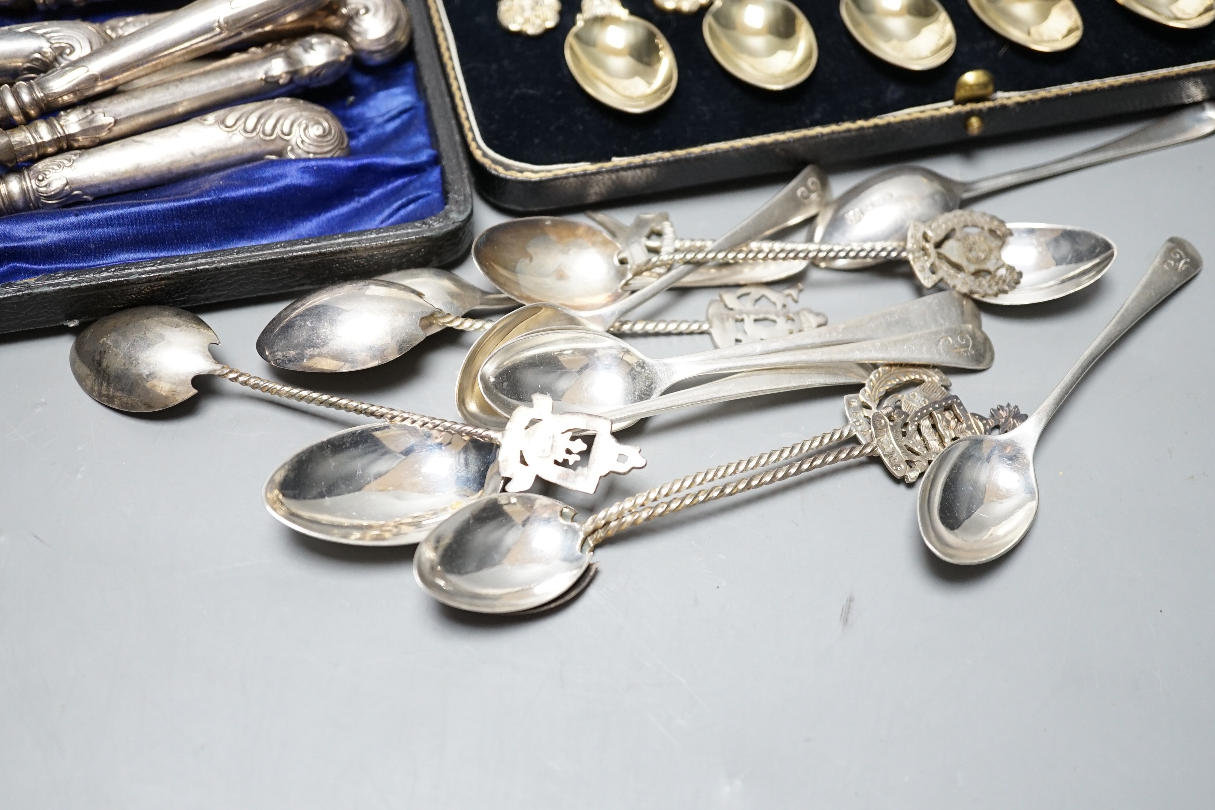 A cased set of twelve Victorian silver gilt teaspoons, London, 1894, six pairs of Edwardian silver pistol handled dessert eaters and four other forks, a set of six Malaysian white metal spoons, a set of six silver coffee